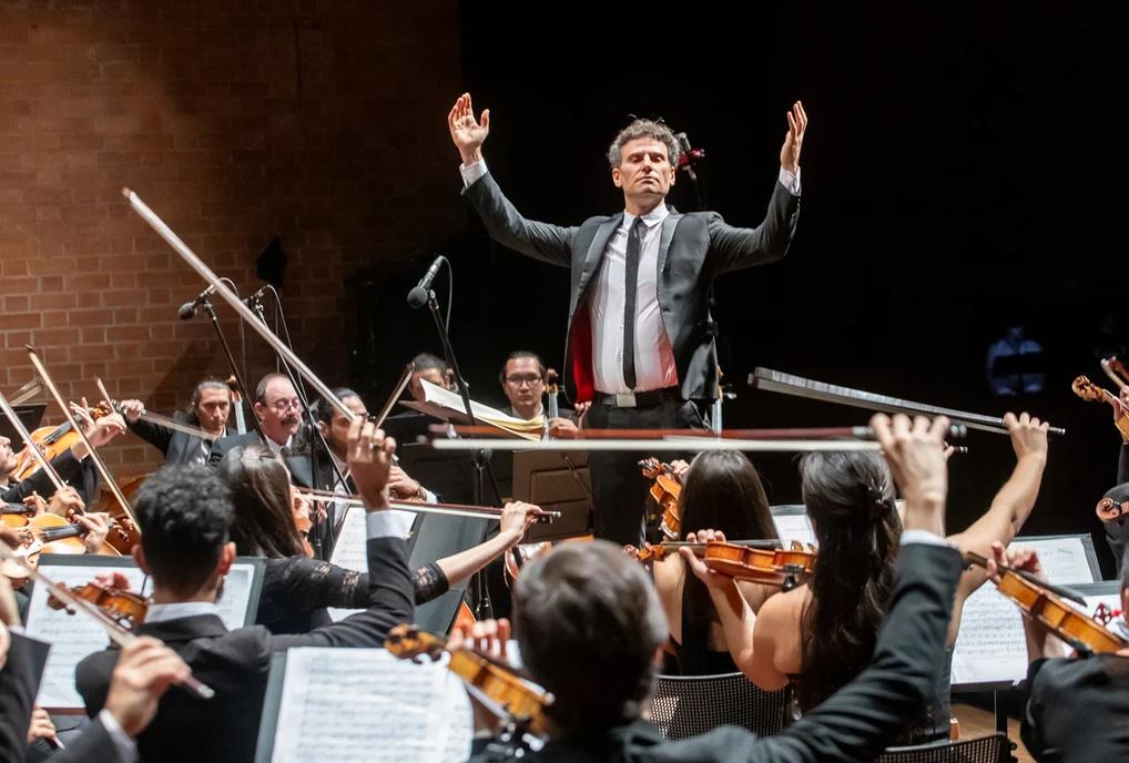 La música clásica en Colombia vivirá un momento histórico con el concierto de Orquestas Unidas, una colaboración única entre la Filarmónica Joven de Colombia y la Orquesta Filarmónica de Medellín. Más de 110 músicos, bajo la dirección del maestro David Greilsammer, se unirán para interpretar un repertorio ambicioso y desafiante, creando una experiencia inolvidable. Este encuentro es una celebración de generaciones: los jóvenes talentos de la Filarmónica Joven de Colombia, orquesta de la Fundación Bolívar Da